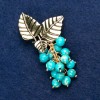 Broche con varisita «Ramita con bayas», color dorado del metal 60 × 35 mm